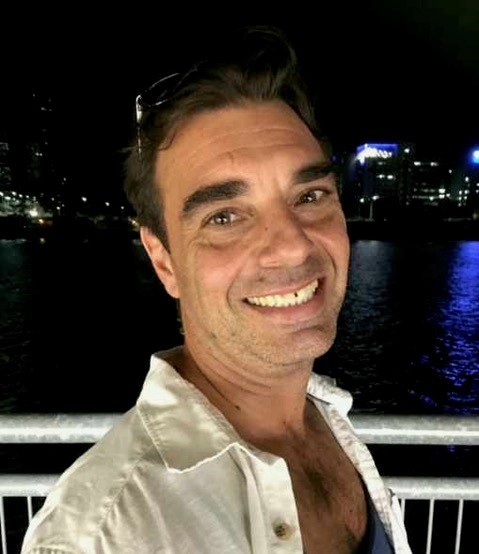 Smiling man standing on bridge at night