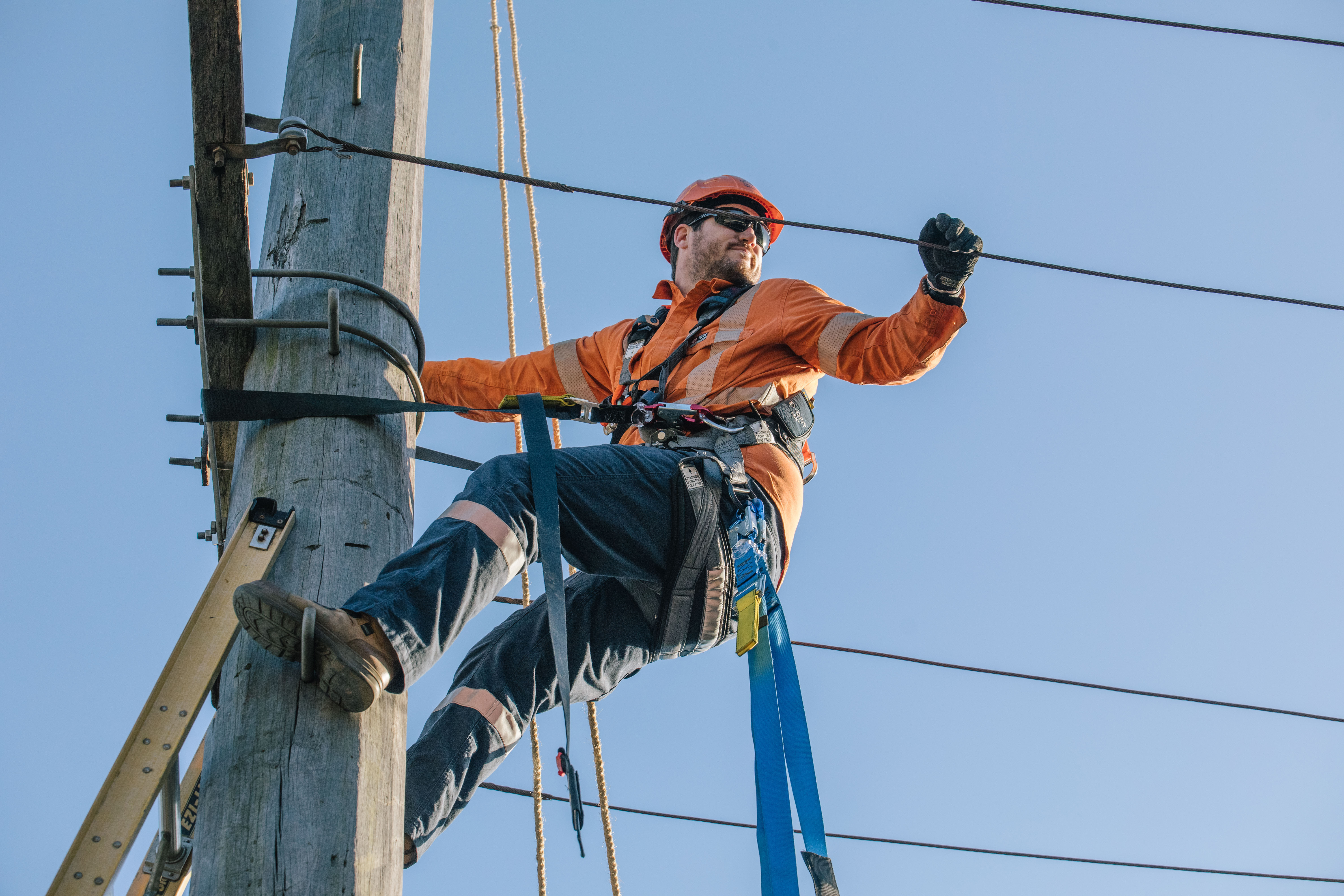 Traction Electrician working from the top of a power pole