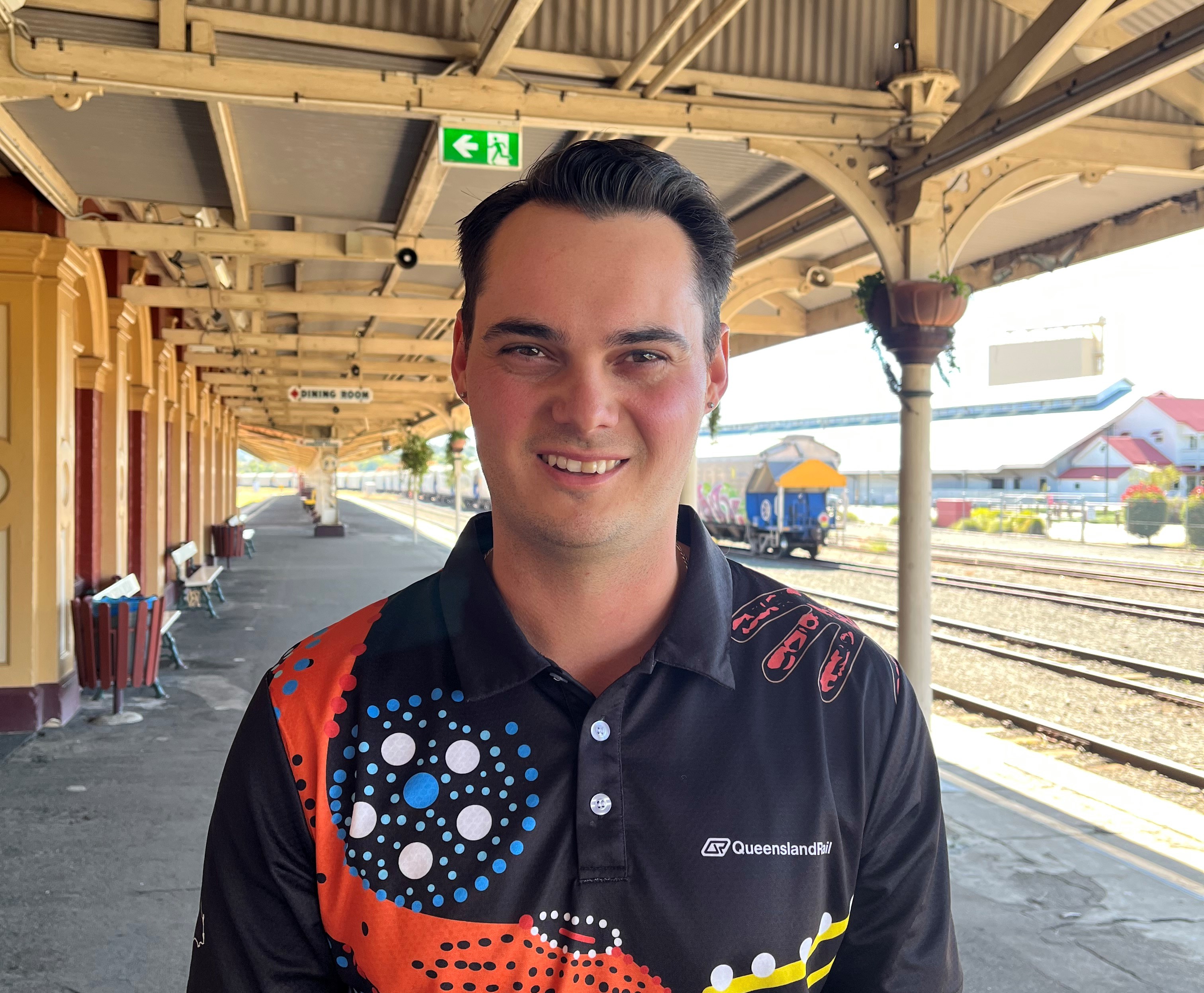 Smiling man on railway platform.