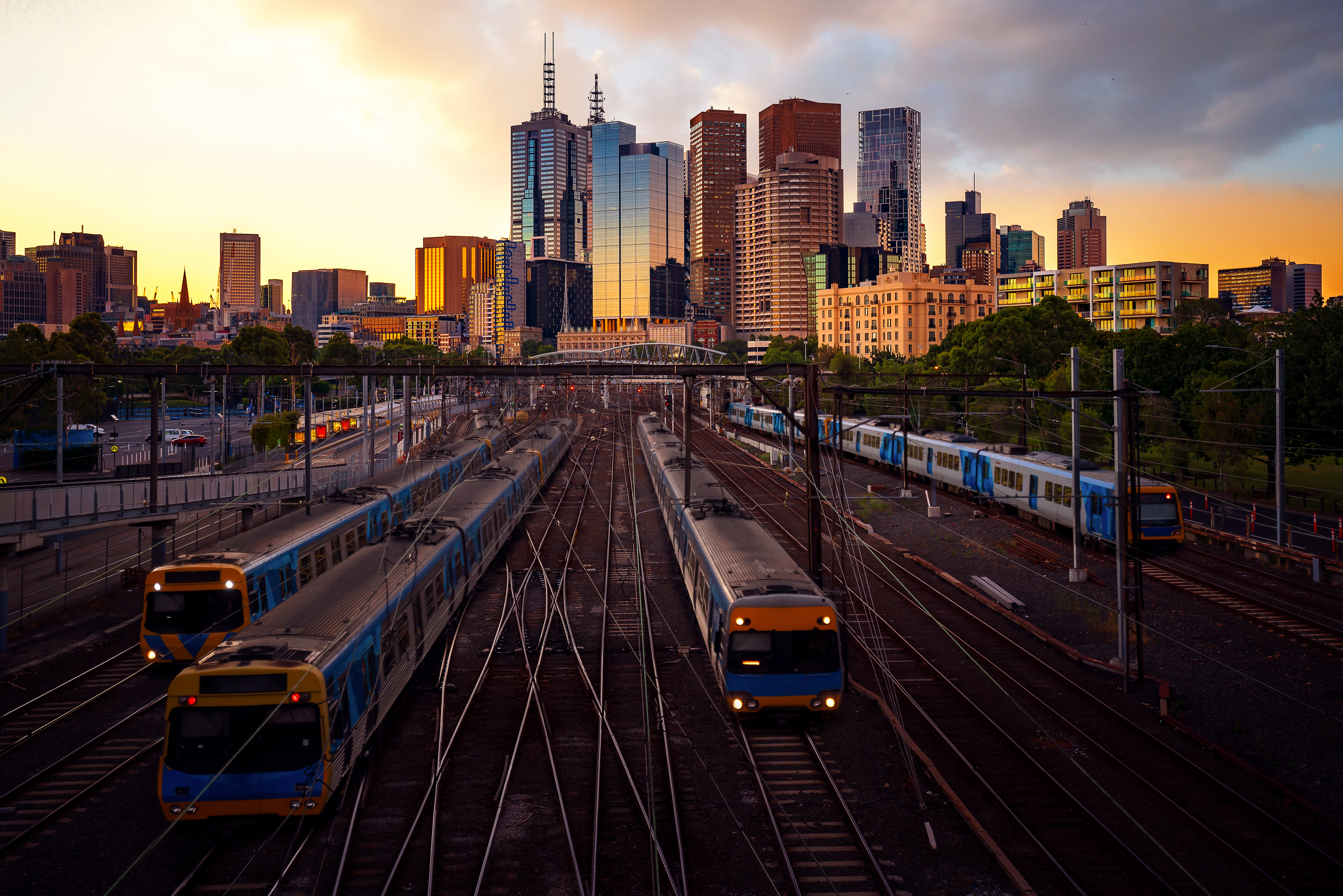 Photo of Melbourne rail yard at sunset with cityscape in background