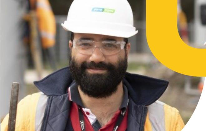 Engineer in hard hat on rail construction site.