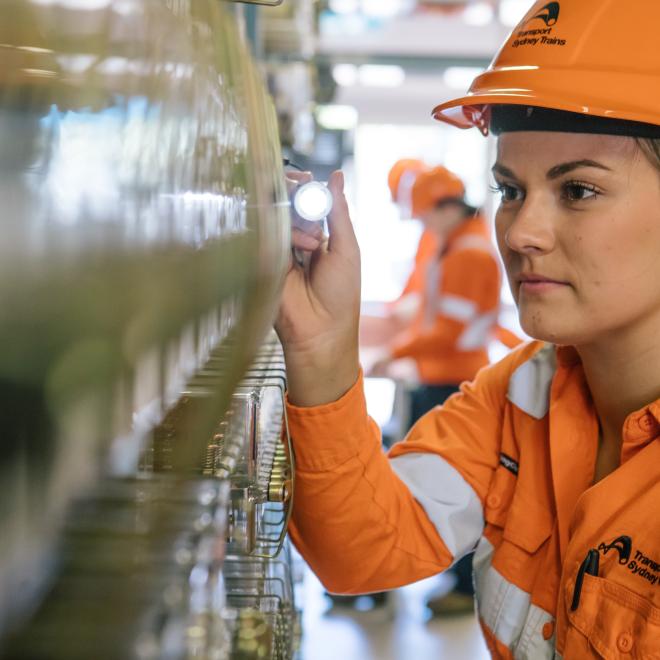 Female rail signalling technician checking signalling technology